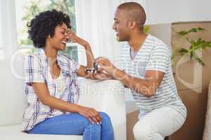 handsome man offering engagement ring to his girlfriend