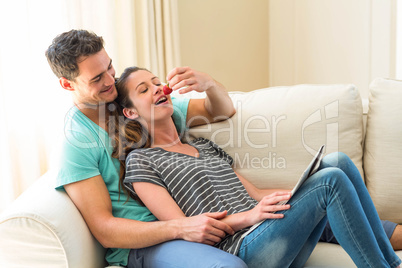 Man feeding a strawberry to woman