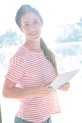 smiling woman holding her tablet computer