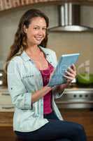 Portrait of woman using tablet in kitchen