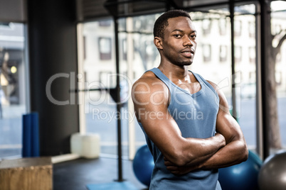 Muscular man standing with arms crossed