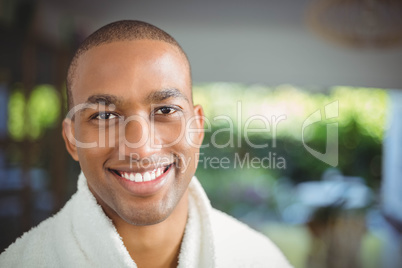 Smiling man in bath robe drinking coffee