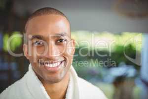 Smiling man in bath robe drinking coffee