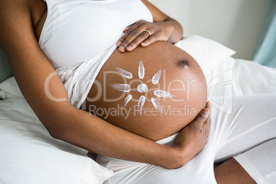 Pregnant woman applying cream on her belly