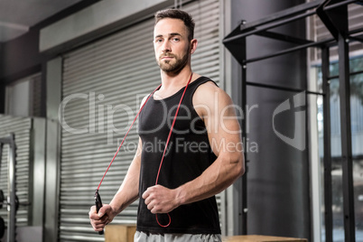 Muscular man holding rope around his neck