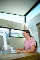 smiling woman sitting at her computer laughing