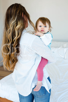woman holding an adorable baby in a bedroom