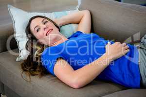 smiling woman lying on the couch relaxing