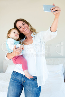 Smiling woman taking a selfie with her baby