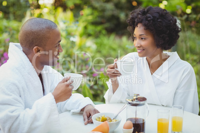 Happy couple taking breakfast in the garden