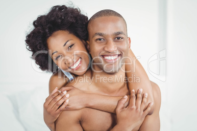 Happy couple embracing on bed