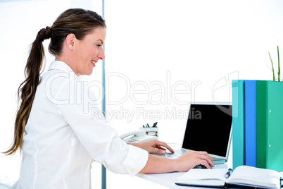 smiling business woman typing on her laptop