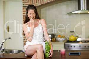 Happy young woman eating vegetable