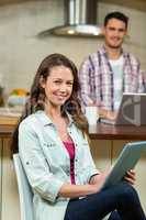 Woman using digital tablet in kitchen