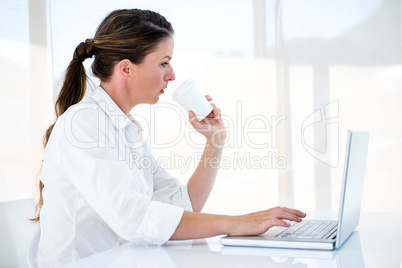 woman on her laptop drinking a coffee