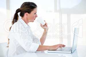 woman on her laptop drinking a coffee