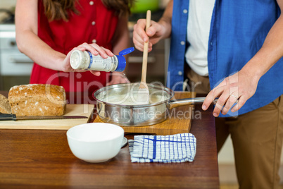 young couple preparing batter in pan