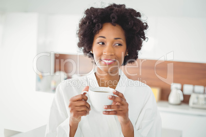 Pretty woman in bath robe drinking coffee