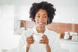 Pretty woman in bath robe drinking coffee