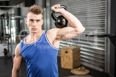 Muscular man lifting heavy kettlebell