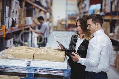 Warehouse managers looking at clipboard