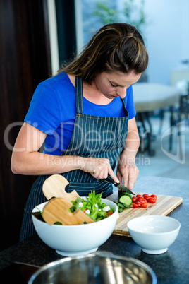 woman preparing sliced vegetables for dinner