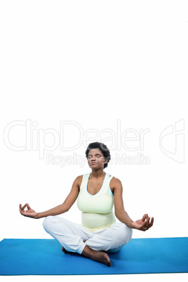 Pregnant woman meditating on mat