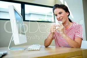 smiling woman sipping a cup of coffee