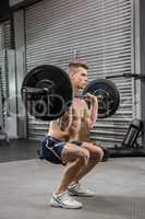 Shirtless man lifting barbell