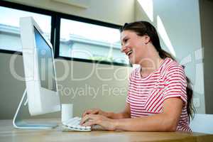 smiling woman laughing at her computer