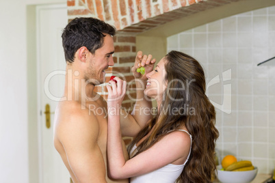 Young couple feeding fruits to each other