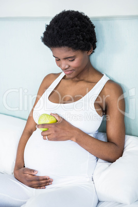 Pregnant woman holding an apple