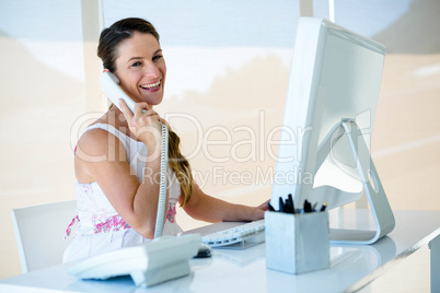 smilingbusiness woman on the phone in her office