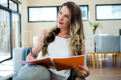 smiling woman writing in a notepad