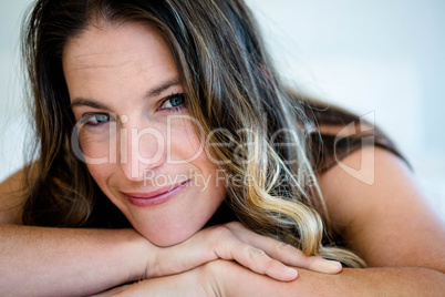 smiling woman resting her head on her  hands