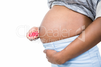 Pregnant woman holding pills in her hand