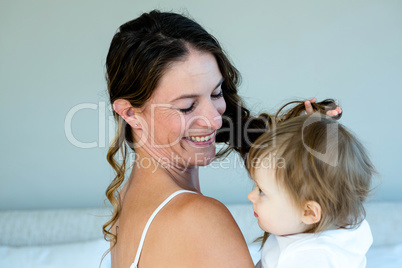 smiling brunette woman holding a playful baby