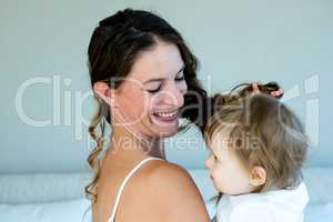 smiling brunette woman holding a playful baby