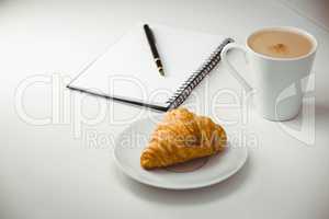 Notebook with pen and coffee by food