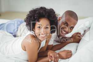 Smiling couple lying on the bed