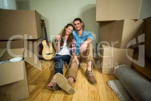 Young couple sitting together on the floor and smiling