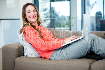 smiling woman typing on her laptop