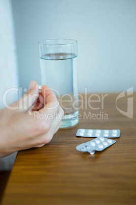 an open packet of pills next to a glass of water
