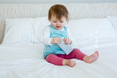 Smiling baby playing with a mobile  phone