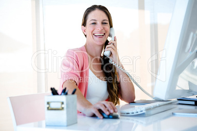 smiling bsuniess woman on the phone in her office