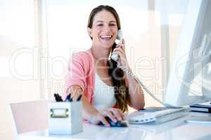 smiling bsuniess woman on the phone in her office