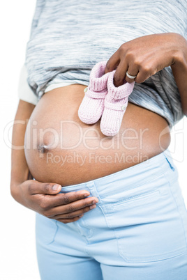 Pregnant woman holding baby shoe