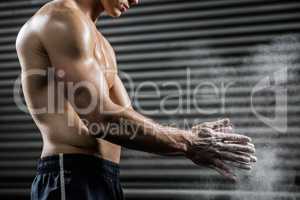Shirtless man clapping hands with talc
