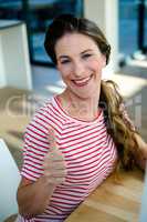 woman smiling at the camera giving thumbs up