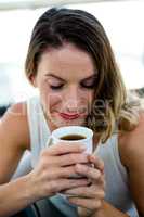 smiling woman sipping a cup of coffee